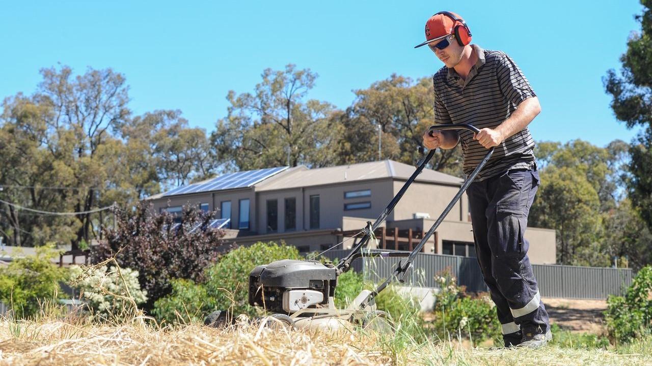 Man mowing dry grass in the summer