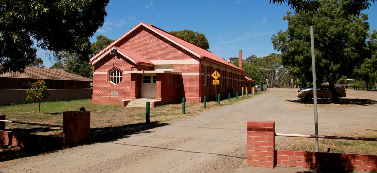 The Axedale Public Hall and Preschool is a brick building with shaded parking and a playspace next door.