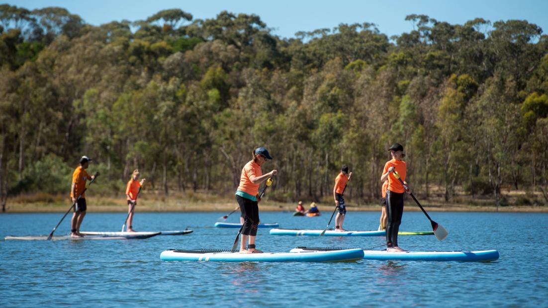 Group of people on paddleboards on the water.