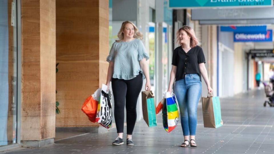 People with shopping bags walking through Hargreaves Mall