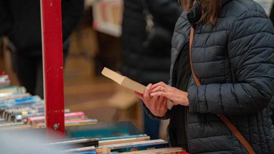 Woman reading the blurb on the back of a book