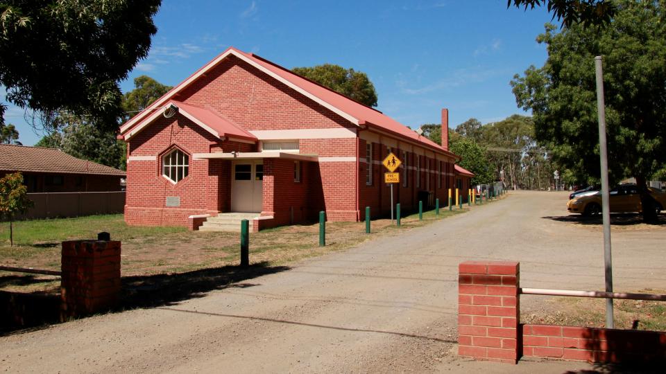 The Axedale Public Hall and Preschool is a brick building with shaded parking and a playspace next door.